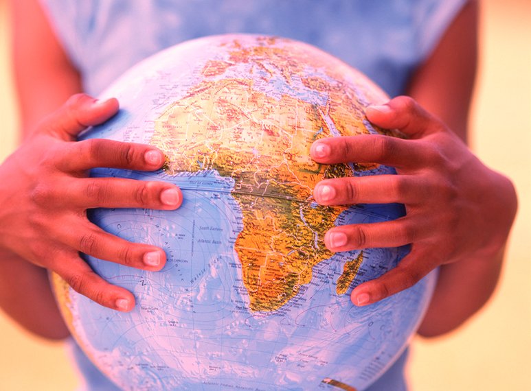 Girl's hands holding globe --- Image by © Royalty-Free/Corbis