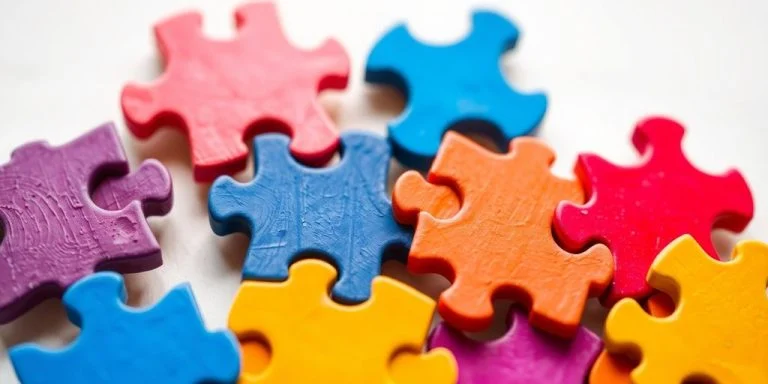Colorful interlocking puzzle pieces on a blurred background.