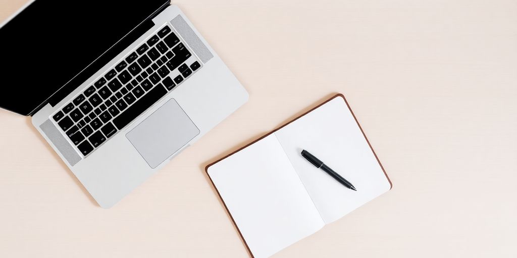 Laptop, notebook, and pen on a desk.