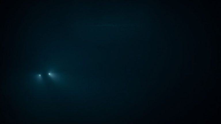 Submarine silhouette beneath a shimmering, distorted ocean surface.