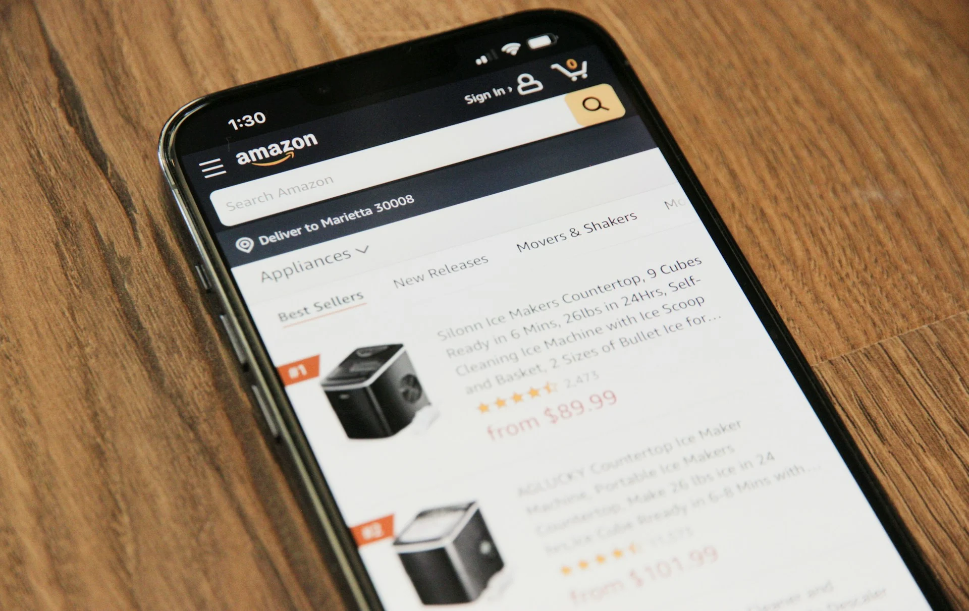 Smartphone on a wooden table with Amazon listings showing.